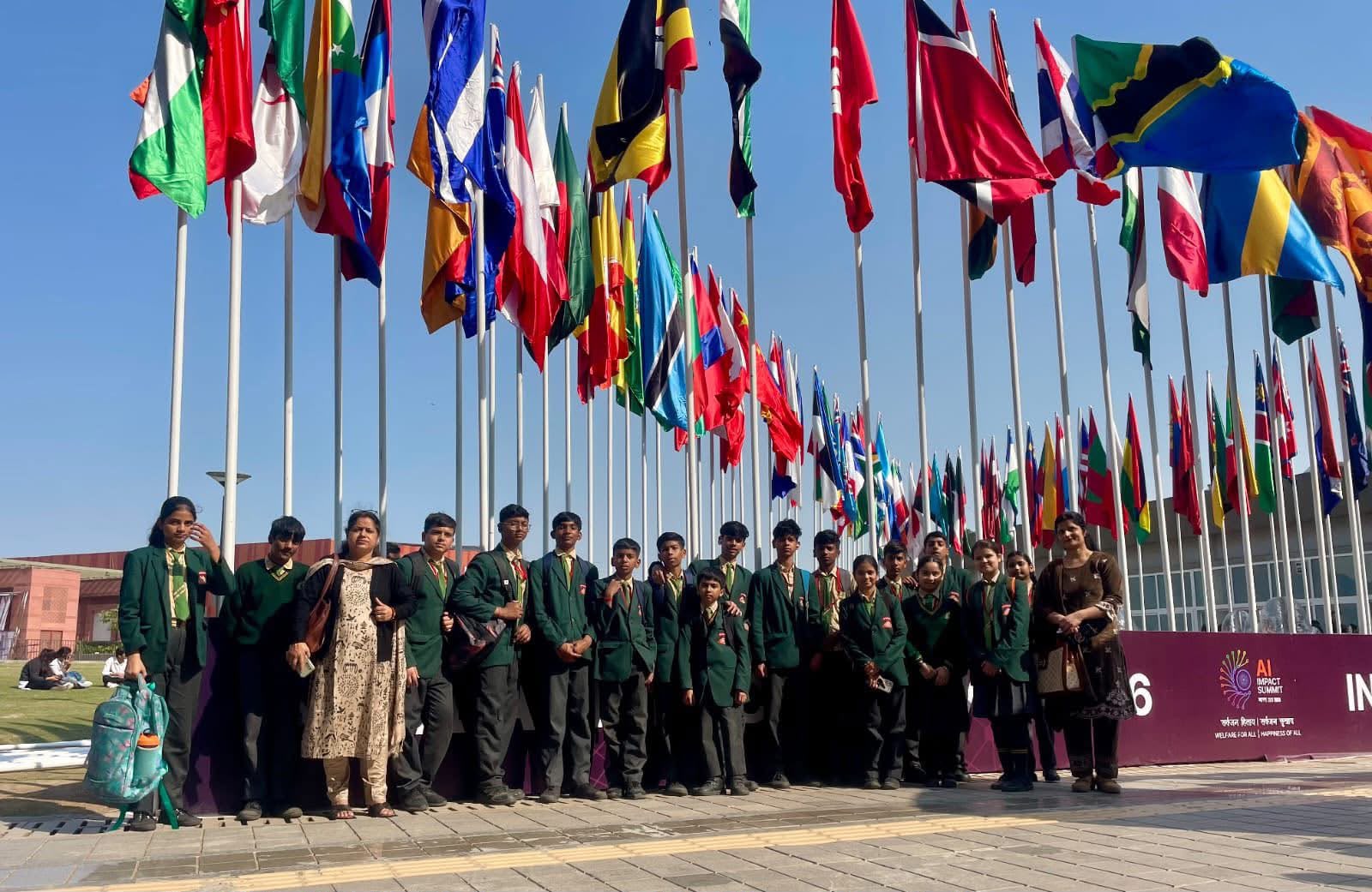 NHCS students before the flags of the world at the AI Impact Summit